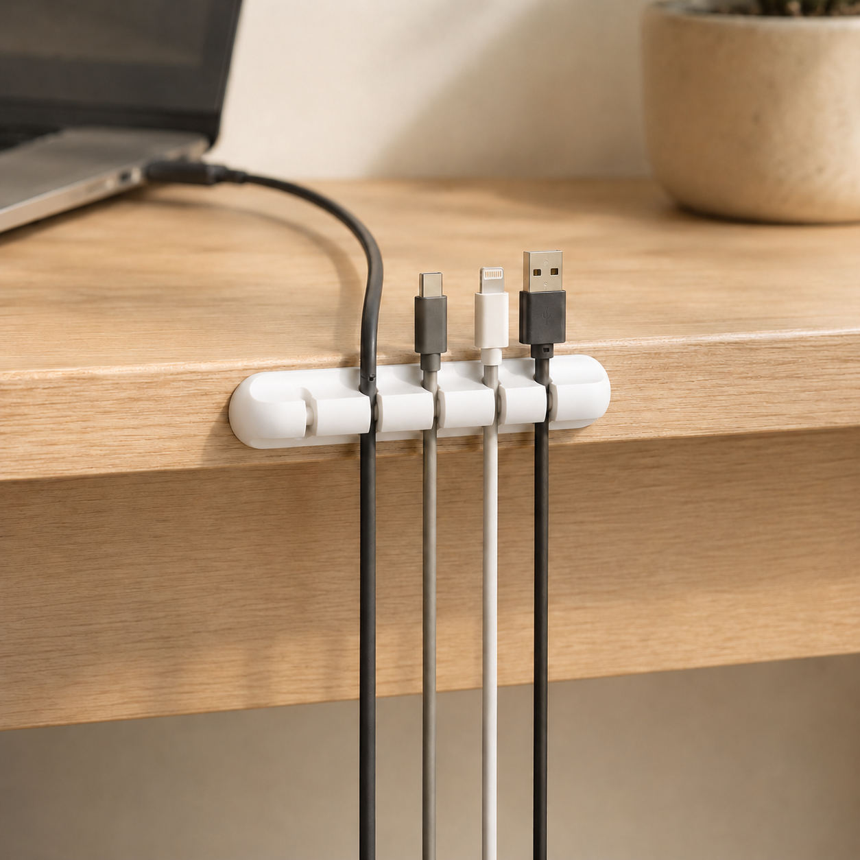 White five-slot adhesive cable holder organising charging cables